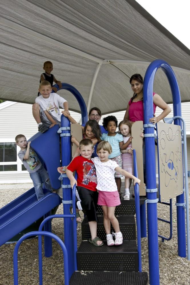 
Children pose for a shot with their child care providers