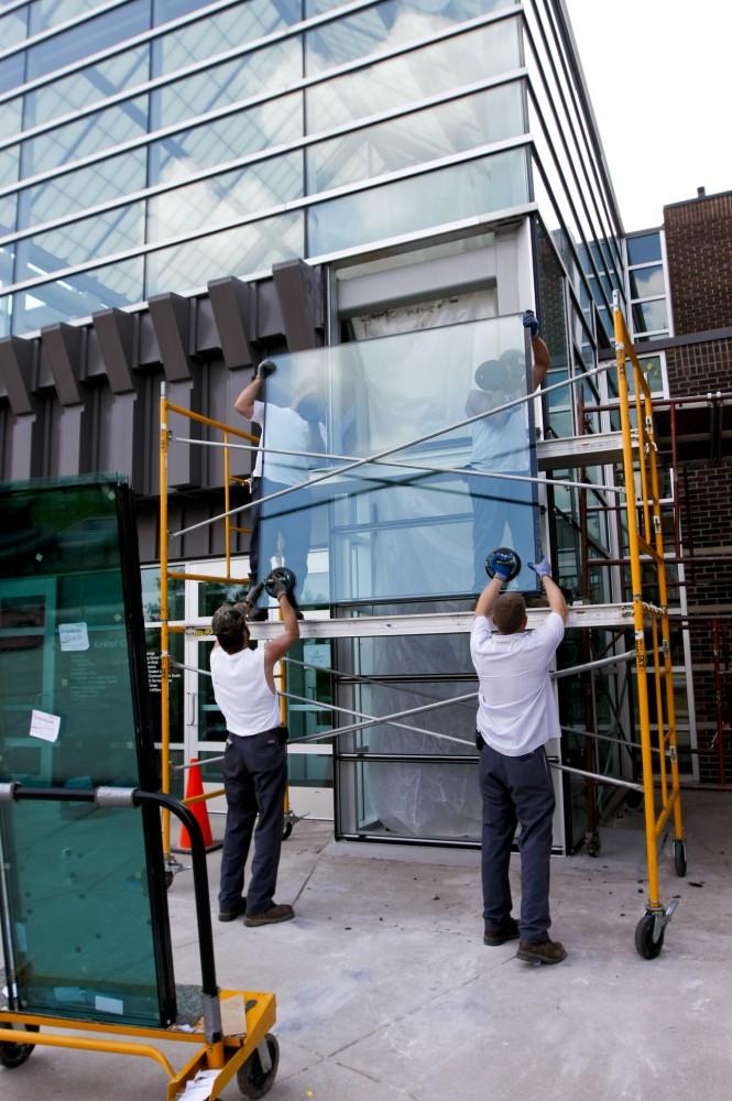 Workers install the new glass at the south entrance of Kirkhof.