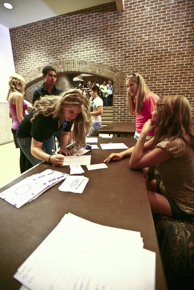 Sophomore Danielle Dodson signs up for the Panhellenic Association after speaking with Senior Jordin Billinghurst.