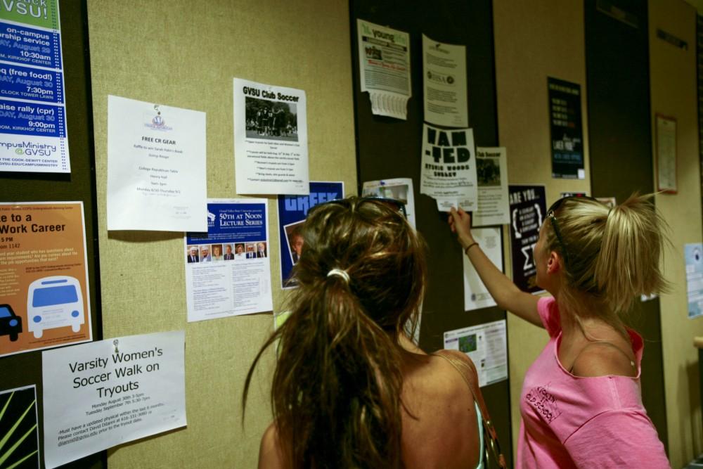 Chelsea Messier and Chelsea Collins look at the events board in Kirkhof.