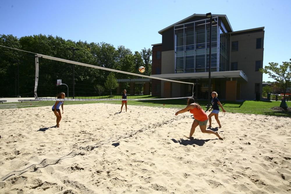 Alyssa  Downey, Jessica Bade, Lisa Barber, and Blair Kronner enjoy the sand volleyball courts.