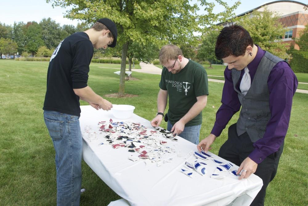 Jerrod Trombley, James Moblo, and Drew Vista attempt to piece together spashed plates at the Paleo-Olympic games