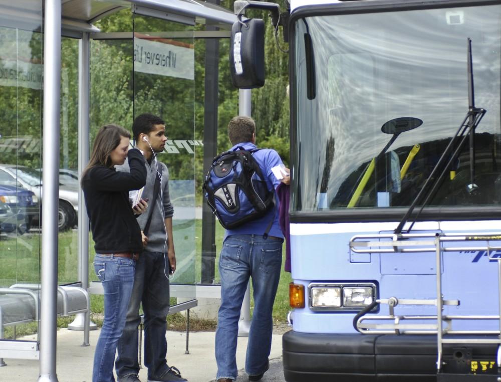Grand Valley students wait to board the bus at the Walker fire station park and ride