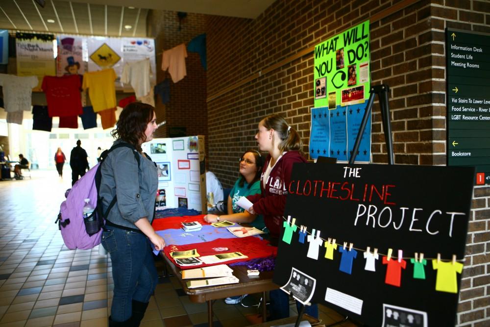 Seniors Allison Smith and Callista Cook give Freshman Brittany Mosti information about the Clothesline Project and Take Back the Night March