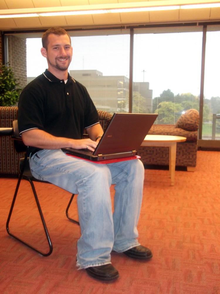 Ryan Lillibridge poses with his laptop invention that cuts harmful exposure from laptops