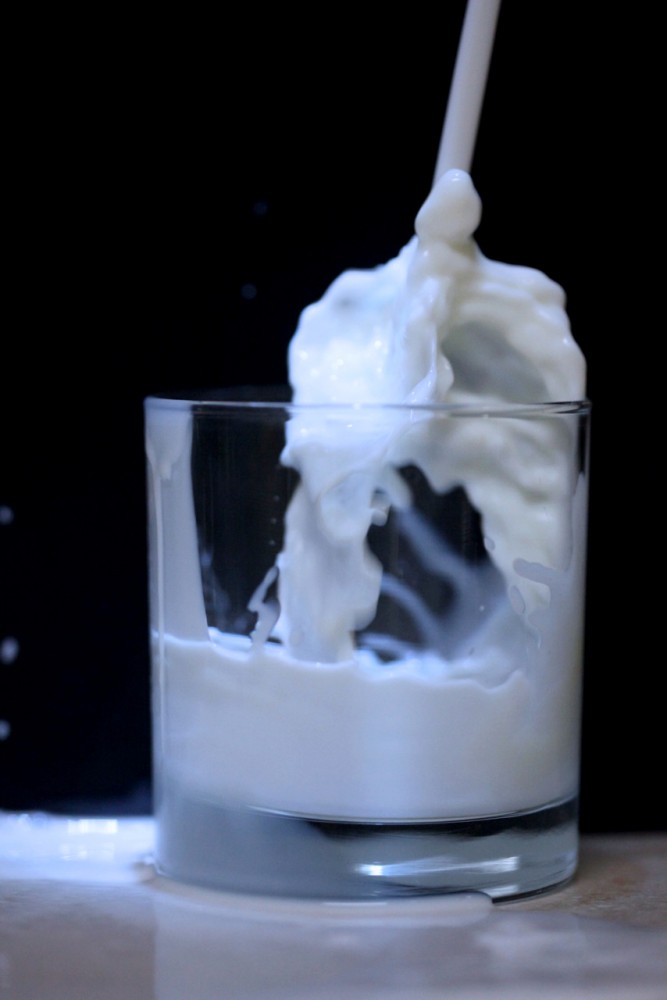 Milk pouring into a cup