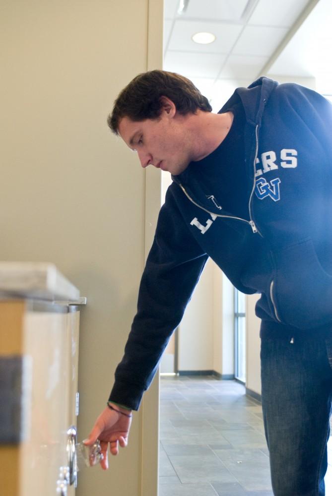 Grand Valley State University junior Logan Short recycles a soda in The Connection.