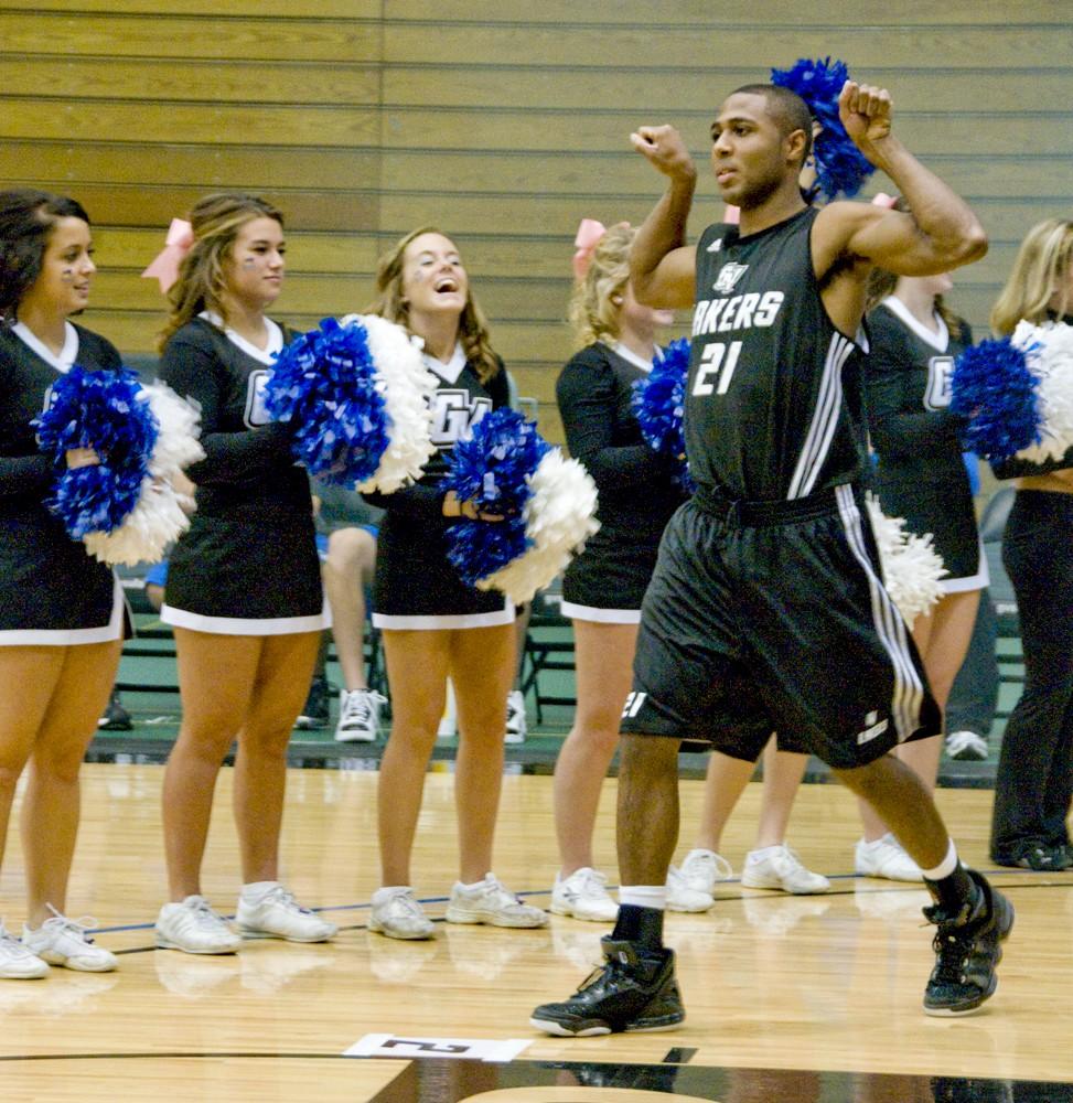 Sophomore Tony Peters runs onto the court as cheerleaders cheer him on during the Tip-Off Madness