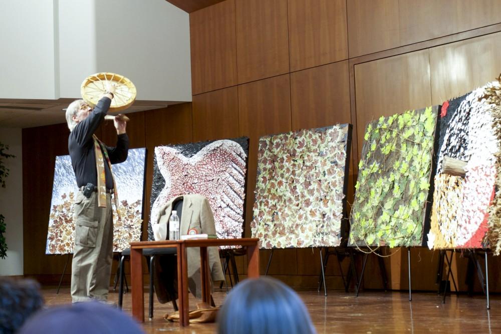 C. Michael Smith, Ph.D, preforms a chant before beginning his lecture "Why Shamanism Now?" last Wednesday. Michael Johnson, the artist whose work is on display, wanted his art to help people re-connect with earth.