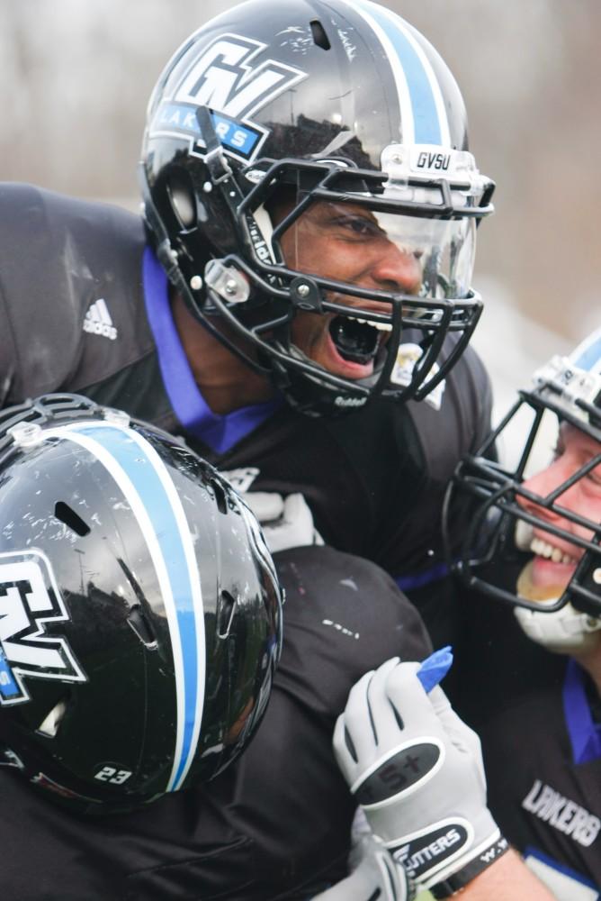 Jovonne Augustus celebrates as teammates hold him up after running a touchdown against Colorado