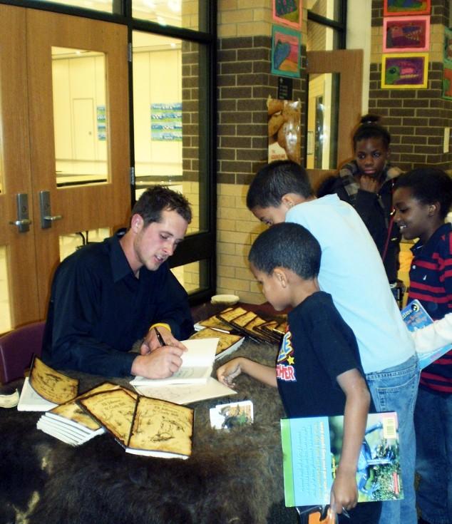 Courtesy Photo / danwrightbokks.com
Dan Wright signs books for students at one of his school visits