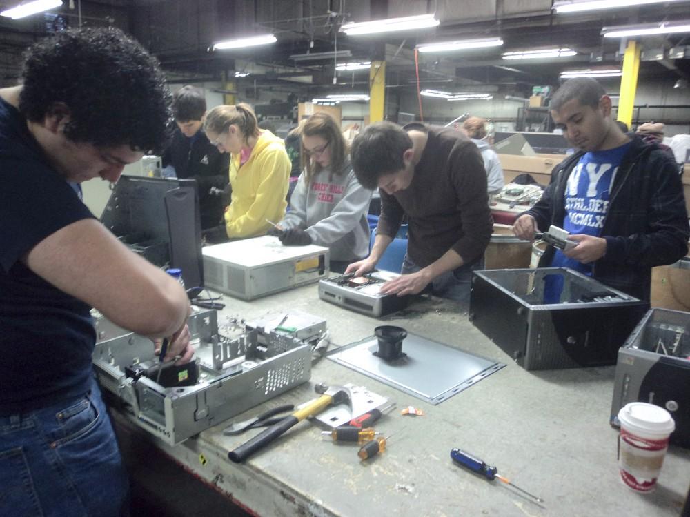 Courtesy Photo / Tijana MatovicVolunteers help disassemble electronic components for recycling at Comprenew, a local business. 