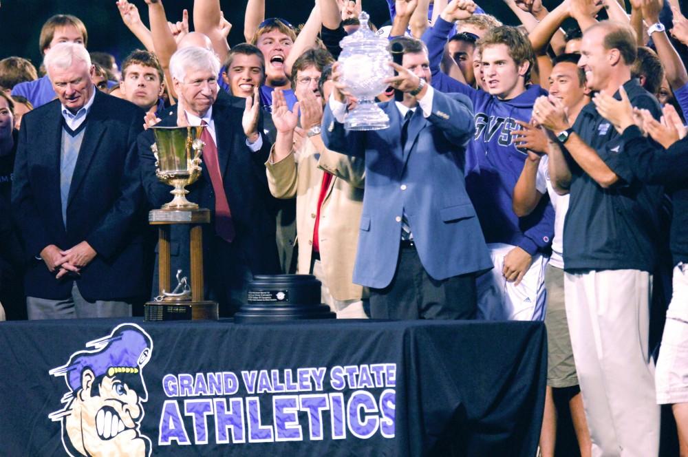 GVL Archive / Andrew Mills
President Haas holds up the Director's Cup as athletes celebrate behind him. GVSU has seven Director's Cups.
