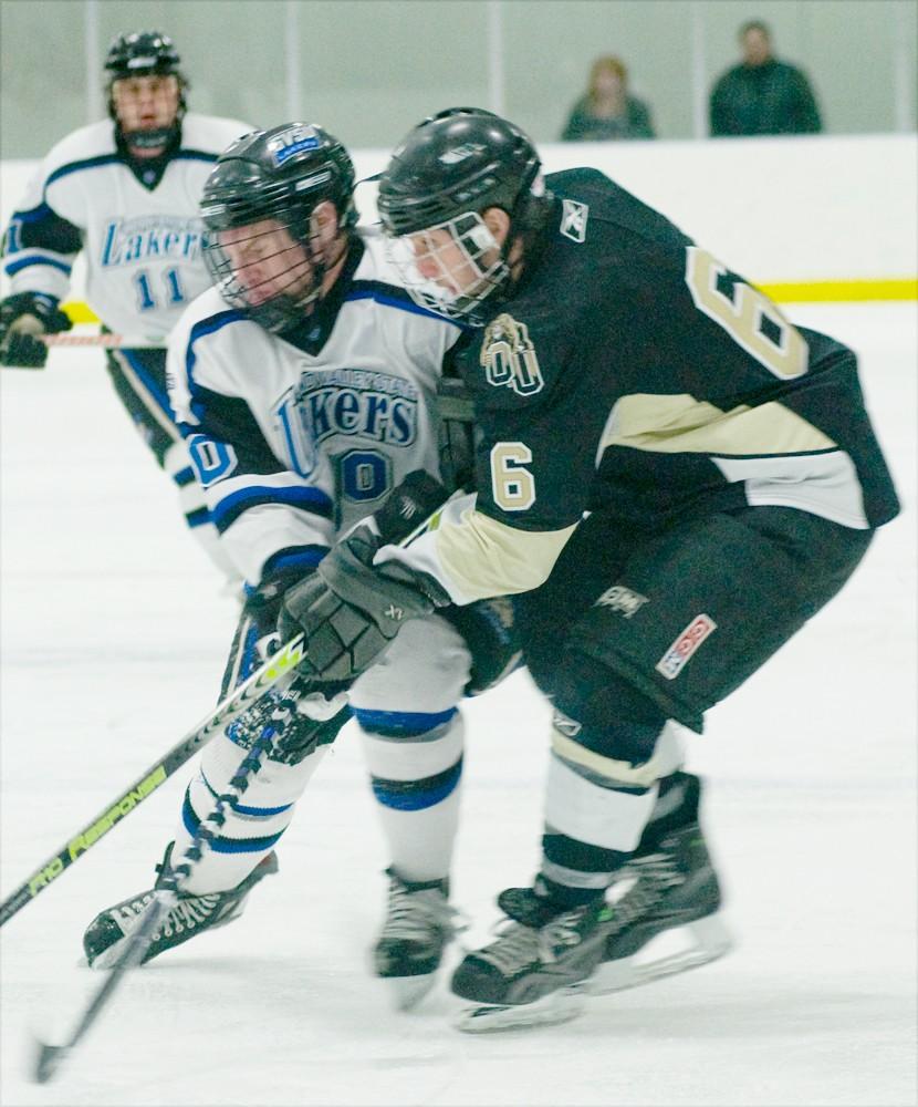 GVL Archive / Nicole Lamson
A member of the GVSU hockey team battles an opponent as teammate Jeremy Christopher looks on