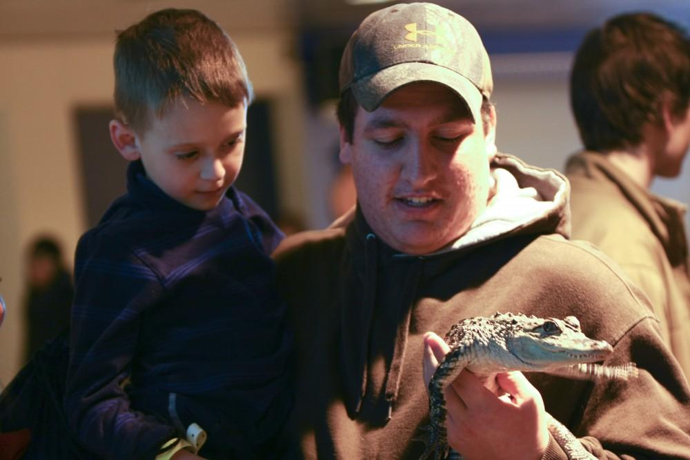 GVL ArchiveA Little Laker checks out a tiny alligator at a past Sibs and Kids weekend