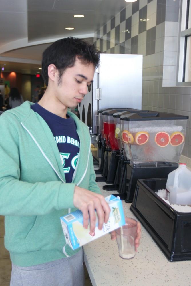 Junior Shawn Czerkis pours soy milk in Fresh Food Company. There are many alternatives for those who have food allergies.