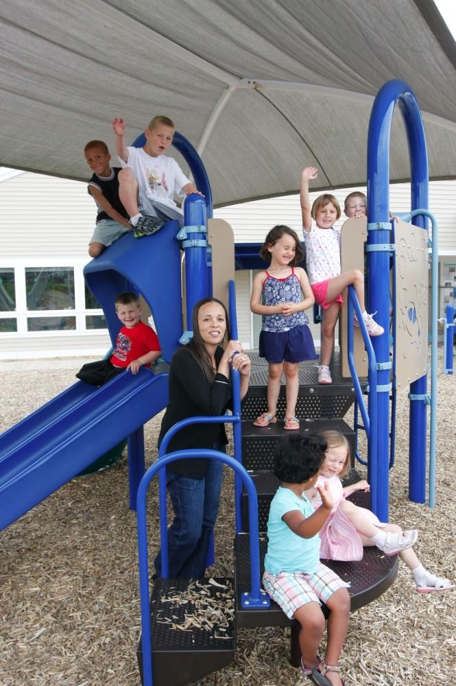 Sharalle Arnold poses with Little Lakers at the Children's Enrichment Center.