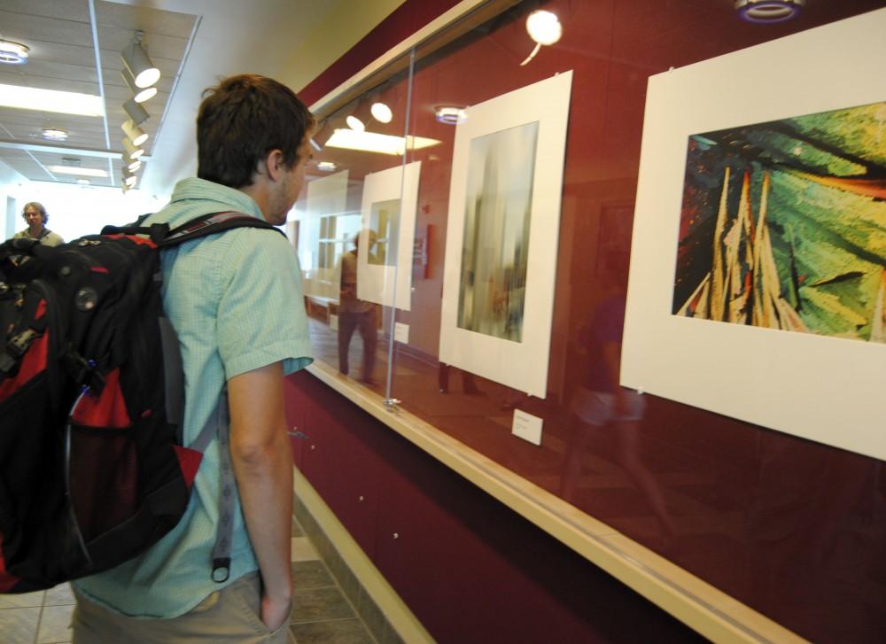 GVL/ Rane Martin
5th year senior Adam Moyer admires the late Robert Koropp's artwork  currently on display on the Red Wall Gallery in Lake Ontario Hall.