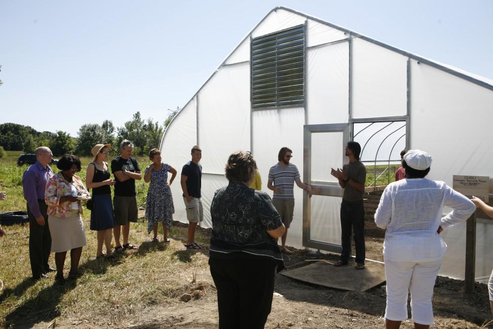 Levi Gardner addresses the attendees at Fridays ribbon cutting from in front of the new hoophouse at the site of GVSUs Sustainable Agriculture Project. 