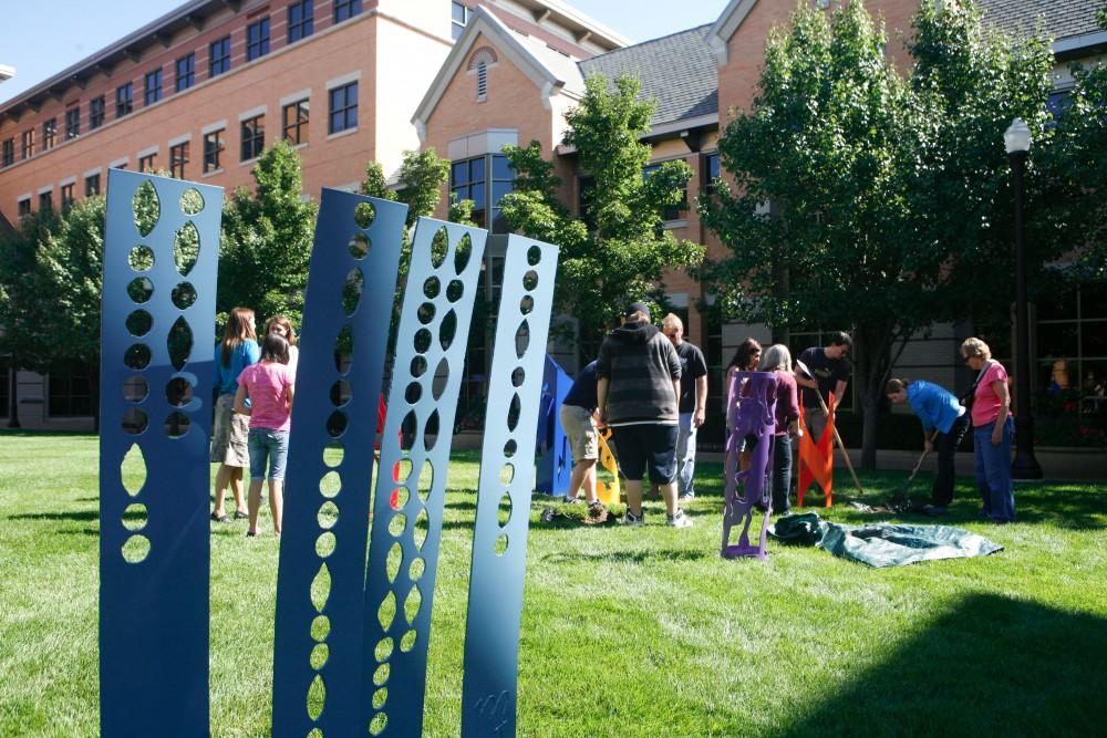 GVL / Eric Coulter
Young artists from the Black River Public Schools and volunteers help out local steel artist Cynthia McKeen set up her collaborative pieces on the lawn of the Pew campus