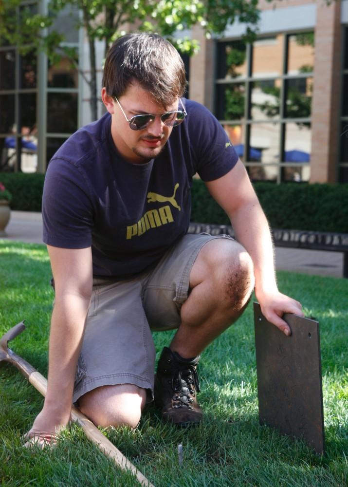 GVL / Eric Coulter
Volunteer Joe Gorris inspects the installation of a work of art that will be showcased on the Pew lawn.