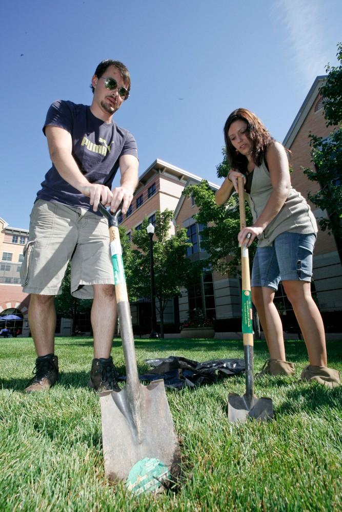 GVL / Eric Coulter
Tara Doyl, a teacher from Black River Public Schools, and Joe Gorris, a CMU student, dig up the ground where the supports for the art pieces that are installed on the Pew lawn.