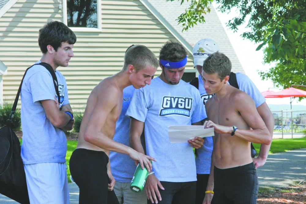 GVL / Andrea Baker
Members of the Cross Country team check the results after the Bulldog Invitational in Big Rapids Saturday