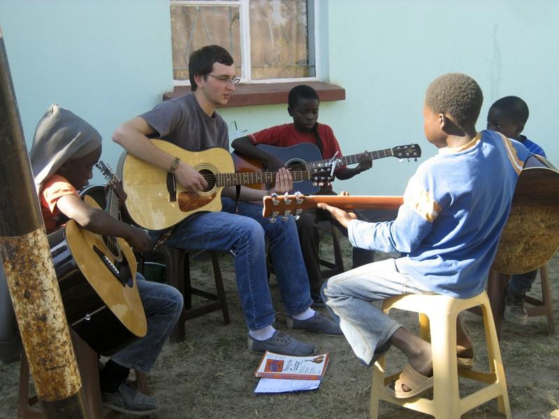Courtesy Photo/Kailtyn Delong
Tyler Stitt, a student from Cornerstone University teaches kids how to play the guitar in Zambia.