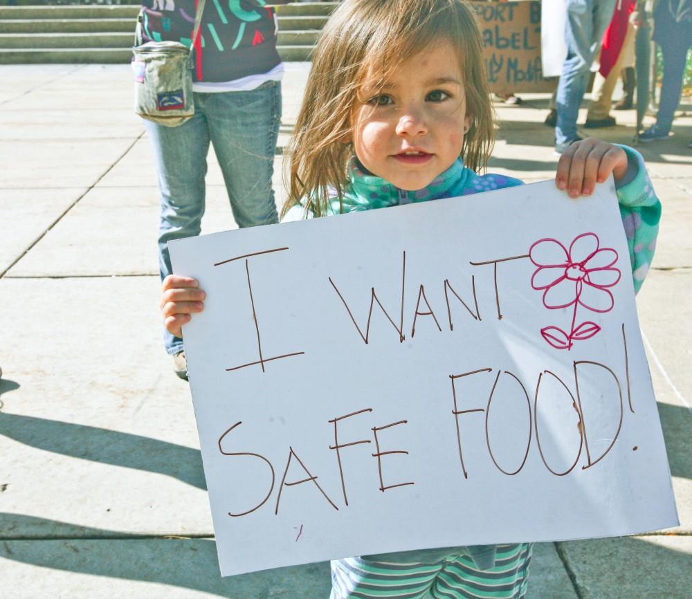 GVL / Anya Zentmeyer
A little protester stands among the Student Environmental Coalition during the march "Millions Against Monsonto" outside of the Grand Rapids City Hall
