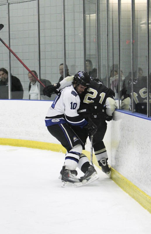 GVL / Robert Mathews
Junior CJ Pobur fights with an Oakland player for possession of the puck.