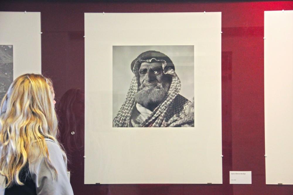 GVL / Rachel Iturralde
A student admires the piece Just a Glint in the Eye by Ilo Battigelli. Battigellis images from Saudi Arabia are featured on the Red Wall Gallery located in Lake Ontario Hall