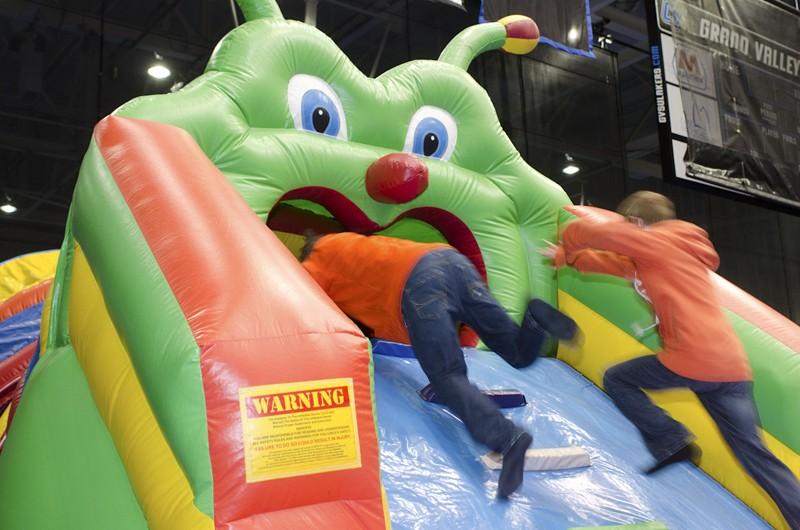 GVL / Bo Anderson
Ryan and Zach, visiting for Sibs and Kids weekend, rush into an inflatable game on Saturday.