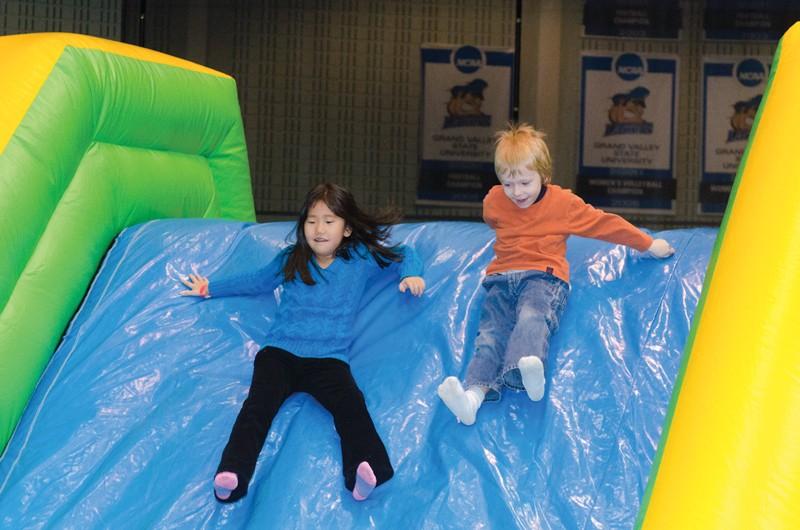 GVL / Bo Anderson
Parker Beard and Mackenzie Watson slide down an inflatable game during GVSU's Sibs and Kids Weekend.