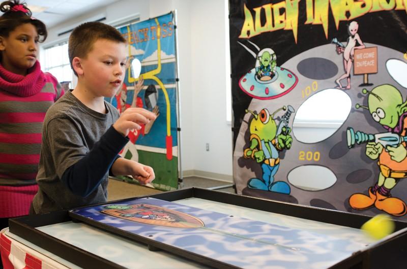 GVL / Bo Anderson
Brian Berrington, visiting his cousin Faith Benson, plays a game in the Kirkhof Center on Saturday.