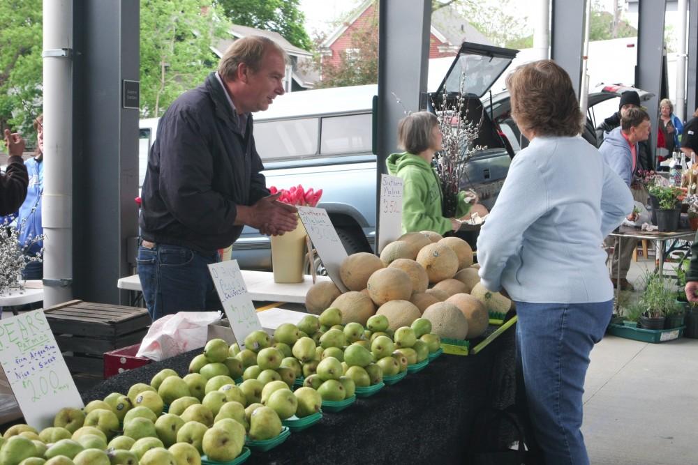 GVL / Eric Coulter
Jeff Dykstra of J. Dykstra Produce assists a customer at the Fulton Street Farmers Market during its opening day on Saturday.  