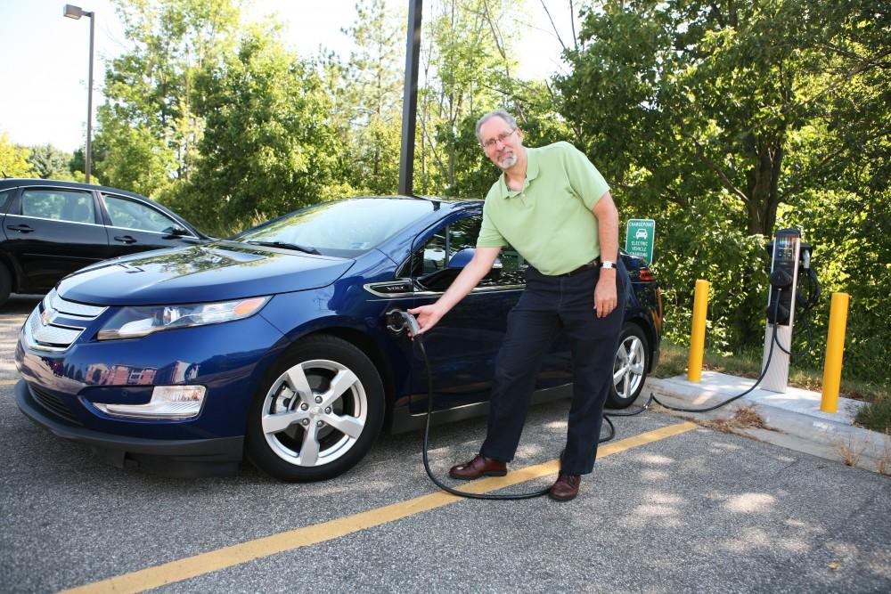 	Jeff Chamberlain, director of the Frederick Meijer Honors College at Grand Valley State University charges his Chevy Volt at an electric charging station on the Allendale Campus. 