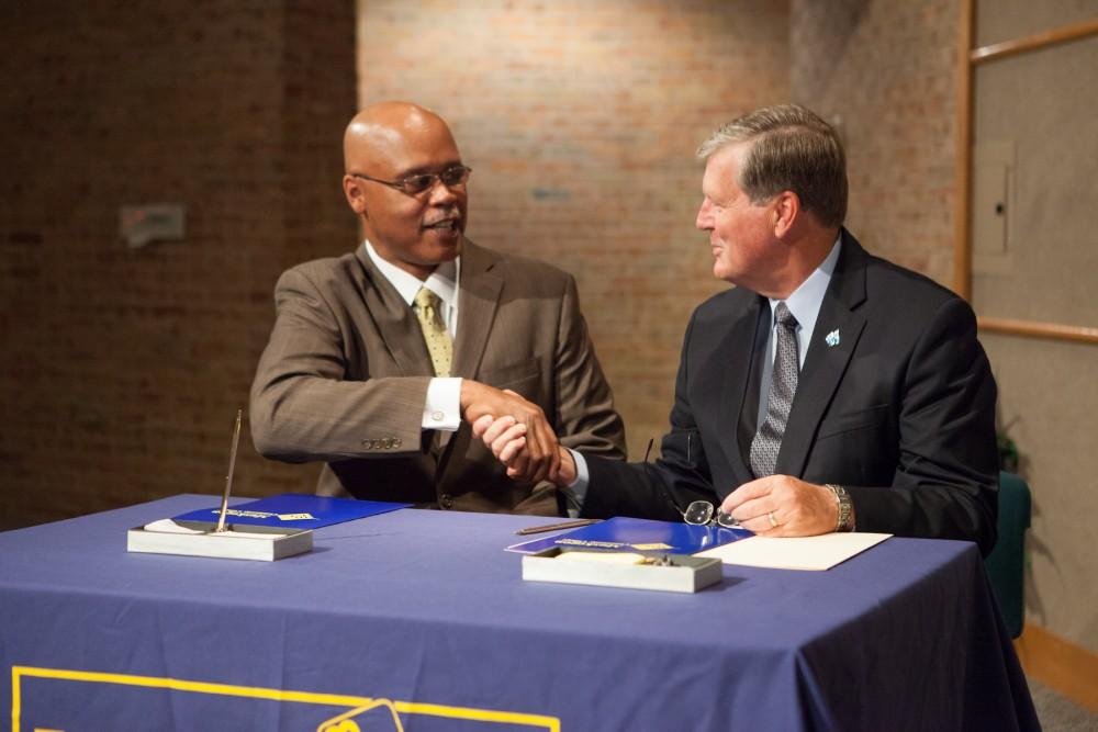 	Dale Nesbary, presidnet of Muskegon Community College (left) shakes hands with Grand Valley State University President Thomas J. Haas following todays signing of a new transfer agreement between the two schools at MCC’s Stevenson Center in Muskegon, Mich. 