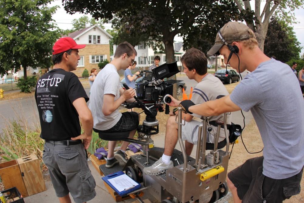 	Grand Valley State University film and video production majors work with the camera on the set of this years’ GVSU Summer Film Series short film, “Realizism” while director, writer and GVSU alumnus Mitch Nyberg watches over them. 