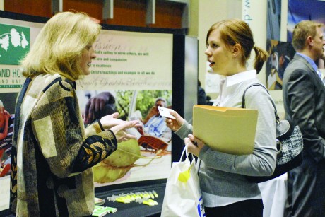GVL / ArchiveGrand Valley student exchanges business cards with a potential employer at a past career fair.