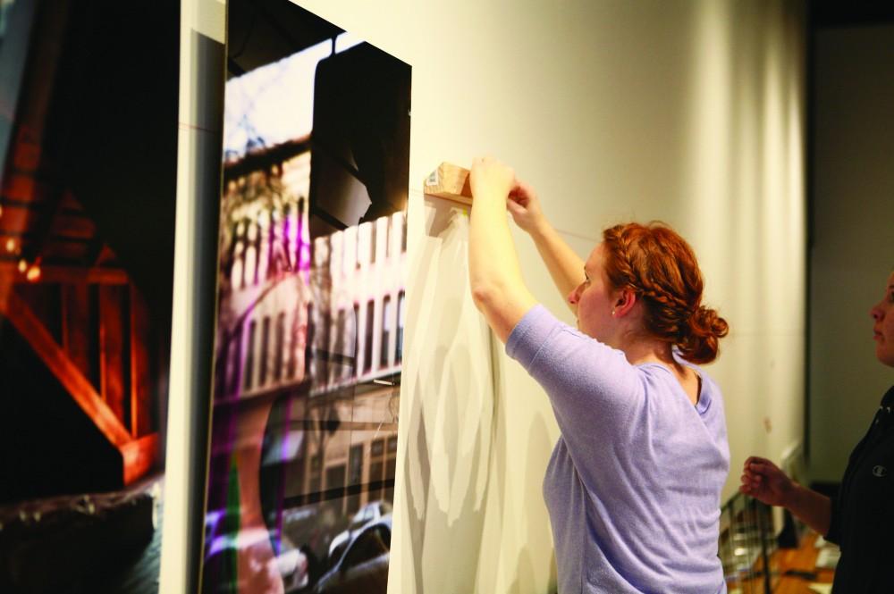 GVL / Robert MathewsApril Galbrath hanging her senior thesis in the PAC Gallery for the Tessalation Photo Show. 