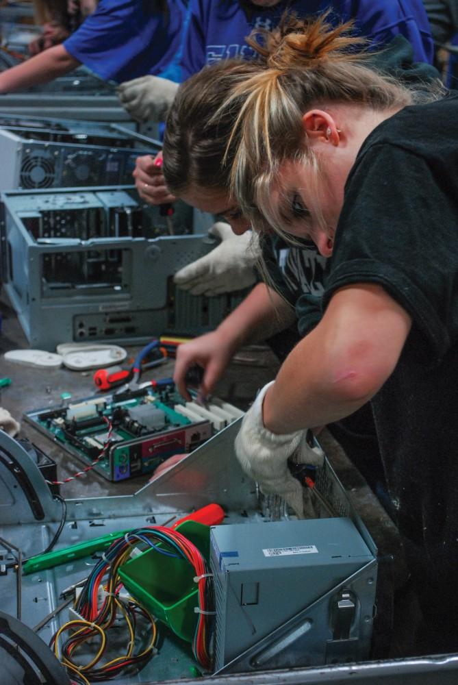 GVL / Hannah Mico. Sam Ladouceur (sophomore) works on disassembling hard drives at Comprenew, an electronis recycling center in downtown Grand Rapids as part of Make a Difference Day.