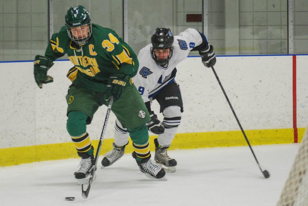 GVL / Hannah Mico. Junior Brad Wilhelm chases down a player from Northern Michigan University.