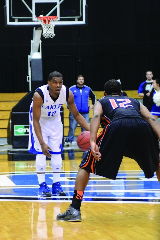 GVL / Hannah Mico. Rob Woodson (senior) checks the court for an open path to Findlays basket.