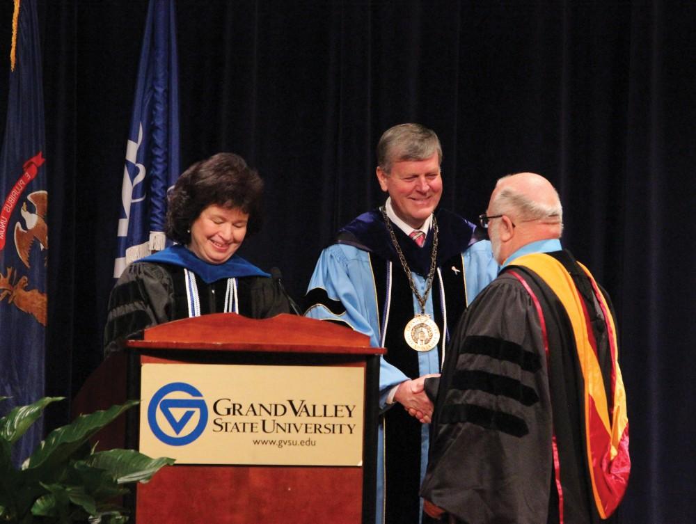 Gayle Davis and President Thomas J. Haas present Paul Jorgensen with an award for serving an outstanding 25 years at GVSU.