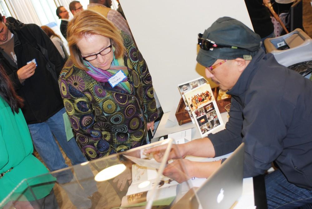 GVL/Brianna Olson
Faculty member Mary Schutten reviews items at Hoon Lees booth
