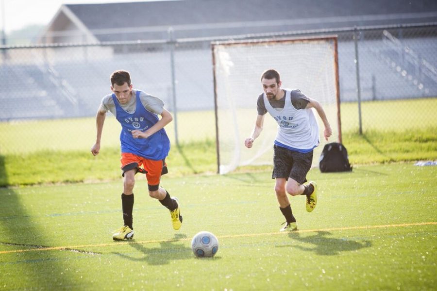 Two members of GVSUs Unified Soccer program race to win a loose ball during a match on Wednesday, June 3. The program will conclude with a championship match on June 10.