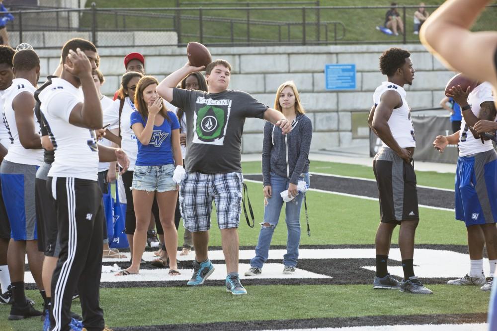 GVL / Kevin Sielaff
Student Zach Powers attempts to throw a football into a corn-hole slot to win a prize. The Grand Valley State University athletics department hosts its annual Fan Fest at Lubbers Stadium Thursday, August 28th, 2015. Incoming freshman and athletes alike swarm the football field for games and activities in a "meet and greet" setting. 