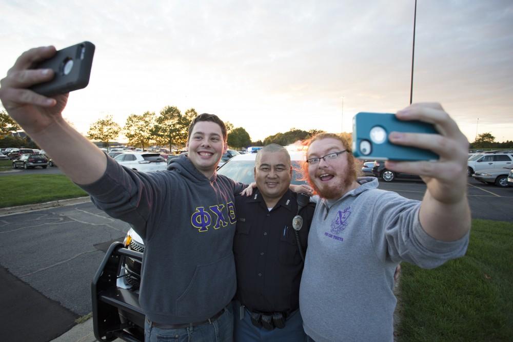 GVL/Kevin Sielaff
Two students pose with officer Minh Lien of the Grand Valley Police Department. Campus Life Night takes place Sept. 13 on the grounds of parking lot H at Grand Valley's Allendale campus. 