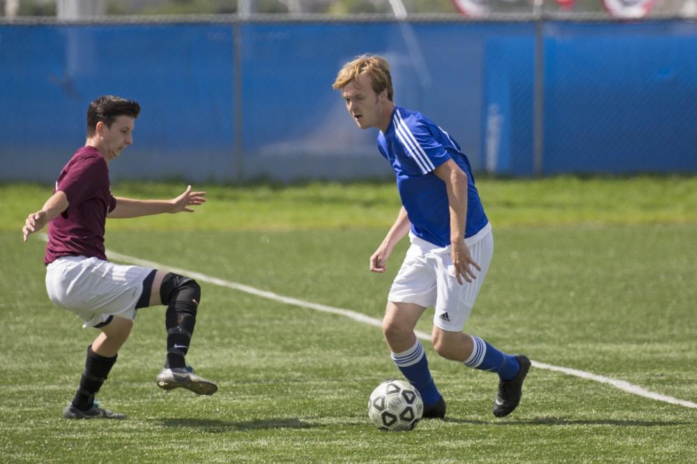 GVL/Kevin Sielaff
Austin Lively moves to dribble around a defender. Grand Valley's club soccer team squares off against Central Michigan Sept. 12 at the intramural field. 