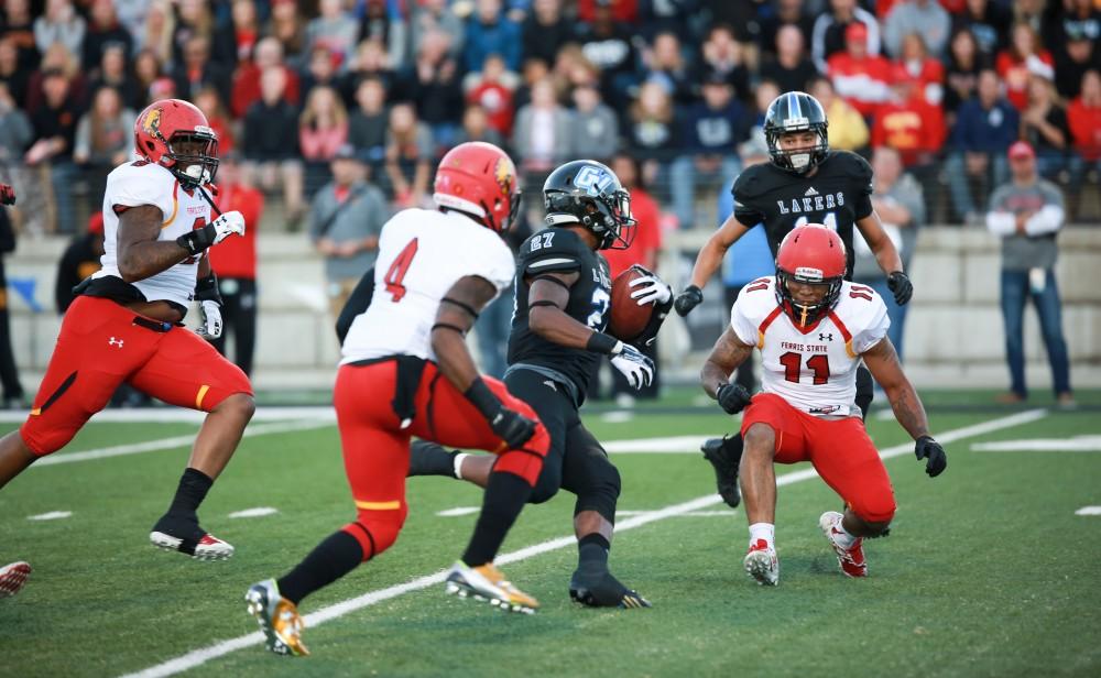 GVL / Kevin Sielaff     Kirk Spencer (27) is tripped up by Jaleel Canty (11) of Ferris.  Grand Valley State University squares off against Ferris State University Sept. 19 at Lubbers Stadium in Allendale. The Lakers were defeated, with a final score of 61-24.